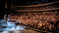 Guns N' Roses performance in front of a large crowd at the Colosseum in Las Vegas