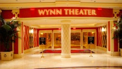 The entrance to the Wynn Theater with its white marble floor, red walls and golden doors.